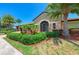 Clubhouse entrance featuring stone facade, arched doorway, and lush tropical landscaping, creating a welcoming and luxurious feel at 135 Sweet Tree St, Bradenton, FL 34212