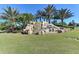 Scenic community entrance sign with a waterfall feature surrounded by greenery at 135 Sweet Tree St, Bradenton, FL 34212