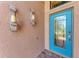 Stylish blue front door with decorative glass panels and elegant candle sconces flanking the entrance at 135 Sweet Tree St, Bradenton, FL 34212