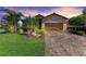 Charming single-Gathering home featuring a brick-paved driveway, lush landscaping, and an attached two-car garage at 135 Sweet Tree St, Bradenton, FL 34212