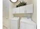 Convenient laundry room with washer, dryer, storage cabinets, and a decorative plant adding style to the functional space at 135 Sweet Tree St, Bradenton, FL 34212