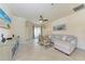 Cozy living room featuring a comfortable sectional sofa, ceiling fan, and sliding glass doors to the lanai at 135 Sweet Tree St, Bradenton, FL 34212