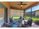 Covered patio with comfortable seating, ceiling fan, and views of the lush backyard and screened-in pool at 135 Sweet Tree St, Bradenton, FL 34212