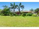Expansive backyard featuring a lush lawn, mature landscaping and views of the screened lanai of this home at 142 Dory Ln, Osprey, FL 34229