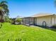 Spacious backyard with manicured lawn, partial screen enclosure, and views of the pool area at 142 Dory Ln, Osprey, FL 34229