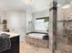 A relaxing bathroom features an oval soaking tub and glass-enclosed shower at 142 Dory Ln, Osprey, FL 34229