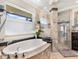 The luxurious bathroom features a large tub, a separate shower, and elegant fixtures at 142 Dory Ln, Osprey, FL 34229