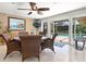 A bright dining area includes a table, chairs, painting and sliding glass doors to the pool at 142 Dory Ln, Osprey, FL 34229