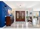 Inviting foyer with tiled floors, high ceilings, statement blue accent wall, and a decorative wood double door at 142 Dory Ln, Osprey, FL 34229