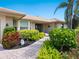 Charming front entrance with decorative landscaping leading to the front door and a stone tile walkway at 142 Dory Ln, Osprey, FL 34229