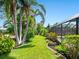 Lush landscaping along a walking path beside the pool lanai creates a private backyard paradise at 142 Dory Ln, Osprey, FL 34229