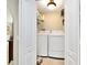 Neat laundry room featuring a washer, dryer, and shelving for easy organization at 142 Dory Ln, Osprey, FL 34229