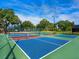 Active community featuring multiple pickleball courts with vibrant blue surfaces and well-maintained green surroundings at 142 Dory Ln, Osprey, FL 34229