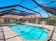 Backyard featuring a screened-in pool and spa with a lounge area and outdoor grill at 142 Dory Ln, Osprey, FL 34229