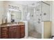 Bathroom featuring a dark wooden vanity with granite countertop and a glass-enclosed tiled shower at 1440 S Keene Rd, Clearwater, FL 33756