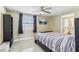 Bright bedroom with tiled floors, ceiling fan, and a wall-mounted TV above the bed at 1440 S Keene Rd, Clearwater, FL 33756