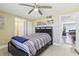 Bedroom featuring tiled floors, ceiling fan, and minimalist decor and doorway to another room at 1440 S Keene Rd, Clearwater, FL 33756