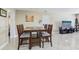 Dining room with tile floors, wood table with seating for four, and view into the living area at 1440 S Keene Rd, Clearwater, FL 33756