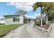 Charming single-story home with a spacious driveway, lush lawn, and a convenient two-car garage at 1440 S Keene Rd, Clearwater, FL 33756