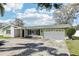 Inviting single-story home with a lush lawn, two-car garage, and a cozy front porch area at 1440 S Keene Rd, Clearwater, FL 33756