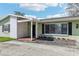 Charming home with a cozy porch, brick accents, and a well-maintained lawn at 1440 S Keene Rd, Clearwater, FL 33756