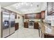 Modern kitchen with granite countertops, stainless steel appliances, and dark wood cabinetry at 1440 S Keene Rd, Clearwater, FL 33756