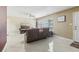 Bright living room with tile flooring, a ceiling fan, and large windows providing plenty of natural light at 1440 S Keene Rd, Clearwater, FL 33756