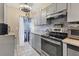 Modern kitchen with gray cabinets, stainless steel appliances, granite countertops, and tile flooring at 1533 42Nd Avenue E Dr # 48, Ellenton, FL 34222