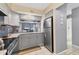 Modern kitchen with gray cabinets, stainless steel appliances, granite countertops, and tile flooring at 1533 42Nd Avenue E Dr # 48, Ellenton, FL 34222