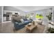 Open-concept living area features a comfortable sofa, kitchen with island, and a dining area at 16198 Arcaro Ave, Port Charlotte, FL 33954