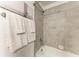 Shower with a gray tile, towel rack and white towels at 18028 Gawthrop Dr # 203, Bradenton, FL 34211