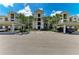 View of condo complex with covered parking and palm trees enhancing its appeal at 18028 Gawthrop Dr # 203, Bradenton, FL 34211