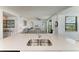 Kitchen island featuring a stainless steel sink, quartz countertops, and open view of living room at 18028 Gawthrop Dr # 203, Bradenton, FL 34211