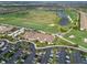Aerial view of a golf course and building surrounded by pristine landscaping and a full parking lot in a residential area at 18028 Gawthrop Dr # 406, Bradenton, FL 34211