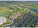 Aerial view of a golf course, parking and building surrounded by pristine landscaping and lakes in a residential area at 18028 Gawthrop Dr # 406, Bradenton, FL 34211