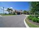 Elegant clubhouse entrance with porte-cochere, lush landscaping, and circular driveway at 18028 Gawthrop Dr # 406, Bradenton, FL 34211