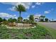 Inviting community entrance featuring a stone waterfall, lush landscaping, and a grand archway at 18028 Gawthrop Dr # 406, Bradenton, FL 34211