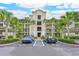 Multi-story condo building with palm trees, covered parking, and designated handicap parking spaces at 18028 Gawthrop Dr # 406, Bradenton, FL 34211