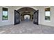 Covered entryway featuring a brick pathway leading through arched wrought iron gates at 18028 Gawthrop Dr # 406, Bradenton, FL 34211