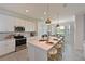 Bright kitchen with stainless steel appliances, white cabinets, and a quartz island with bar seating at 18028 Gawthrop Dr # 406, Bradenton, FL 34211