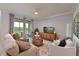 Open living room with a cozy sofa, stylish chairs, and sliding doors to a scenic balcony view at 18028 Gawthrop Dr # 406, Bradenton, FL 34211