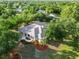 Aerial view of a charming home with a well-manicured lawn, a garden, mature trees, and a welcoming front entrance at 1860 Citron St, Punta Gorda, FL 33980