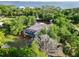 Aerial view showcases a home with a screened pool, enveloped by trees and verdant landscape near the water at 1860 Citron St, Punta Gorda, FL 33980