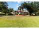 Well-maintained backyard with mature trees, lush lawn, and a view of the home's screened lanai at 1860 Citron St, Punta Gorda, FL 33980
