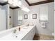 Well-lit bathroom featuring double sinks, large mirror, and striped wallpaper at 1860 Citron St, Punta Gorda, FL 33980