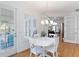 Bright dining area features a modern chandelier, shuttered windows, and white table and chairs at 1860 Citron St, Punta Gorda, FL 33980