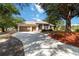 Charming single-story home featuring a circular driveway, manicured landscaping, and an attached two-car garage at 1860 Citron St, Punta Gorda, FL 33980