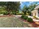 Lush front yard with mature trees, manicured bushes, and mulch beds enhancing curb appeal at 1860 Citron St, Punta Gorda, FL 33980