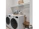Laundry room with front load washer/dryer, storage shelves, and a built-in folding table at 2017 Woodleaf Hammock Ct, Bradenton, FL 34211