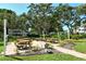Serene common area with picnic tables, mature trees, and lush landscaping at 2227 Sunset Dr # E22, Bradenton, FL 34207